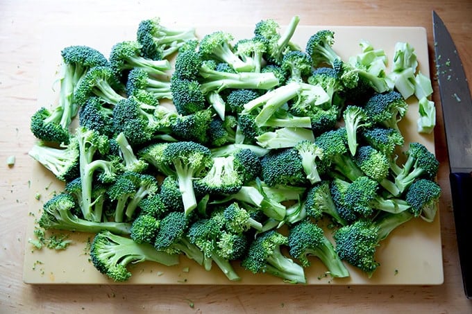 A cutting board topped with broccoli florets.