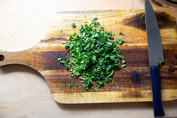 Chopped cilantro on a cutting board.