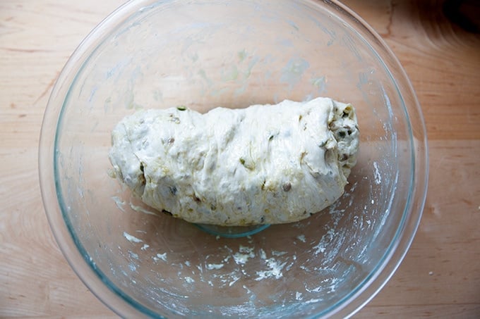 Three seed bread dough, deflated and rolled into a coil, ready for the loaf pan.