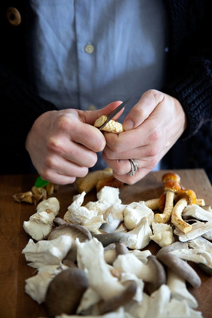 Colu Henry slicing mushrooms over a cutting board.