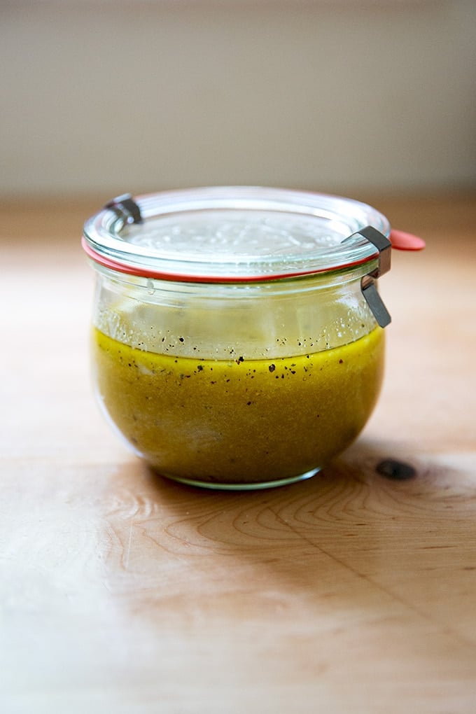 A jar of Greek salad dressing on a countertop.