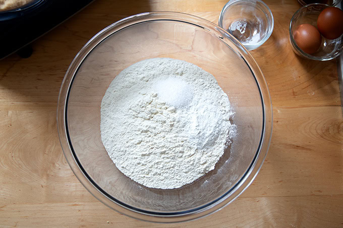 A large bowl filled with the dry ingredients to make soft and chewy chocolate chip cookies.