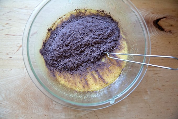 The dry ingredients to make brownies added to the wet ingredients in a large bowl.
