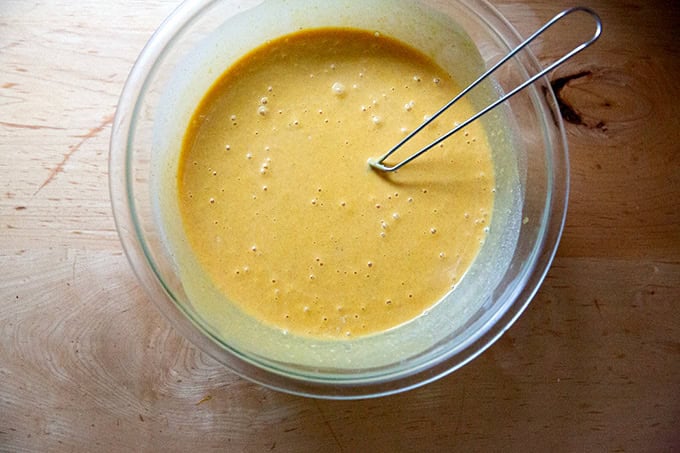 The filling for butternut squash pie whisked together in a large bowl.