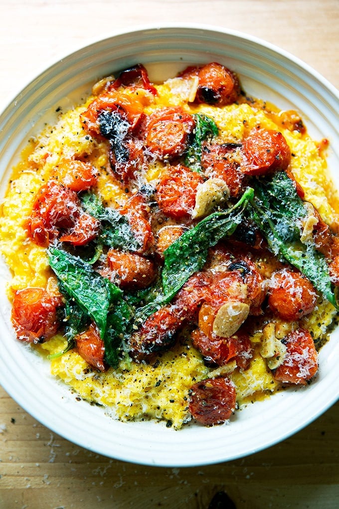 A bowl of fresh corn polenta with blistered cherry tomatoes.