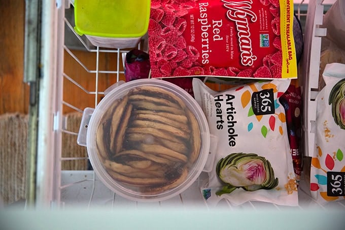 A large container filled with sourdough discard pancakes in the freezer.