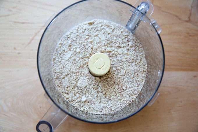 A food processor filled with ground almonds.
