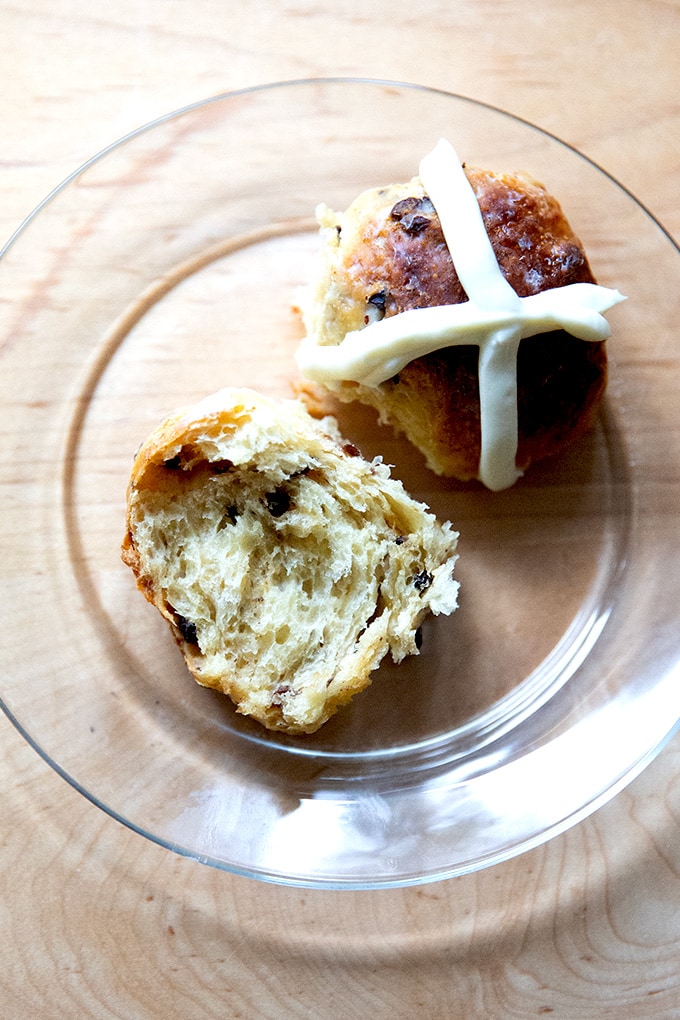 A halved hot cross bun on a plate.