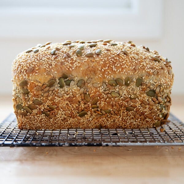Just-baked three seed bread on a cooling rack.