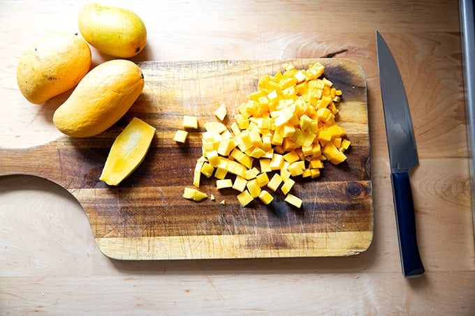 Dice mango on a cutting board.