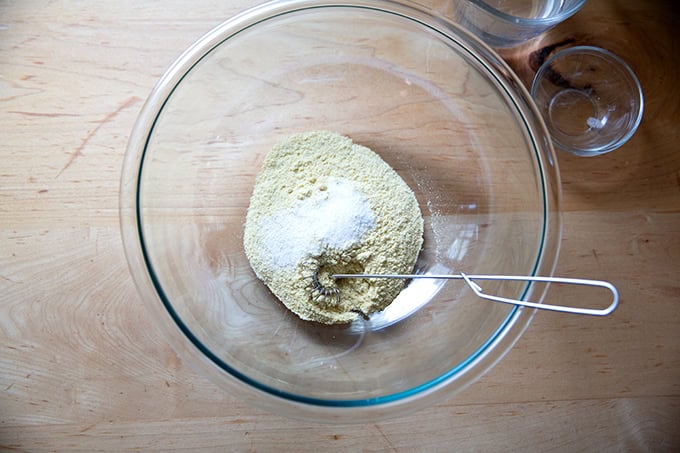 A bowl of masa harina and salt, not yet mixed together.