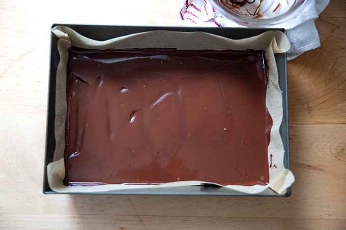 A layer of melted dark chocolate spread into a 10x14-inch pan.