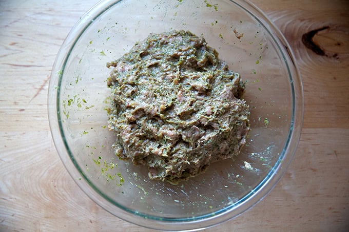 Ground turkey and its flavoring sauce all mixed together in a large glass bowl.