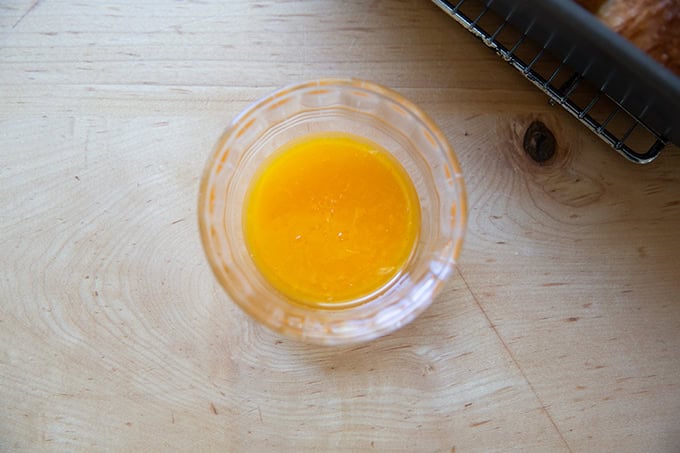 A small bowl of orange glaze.