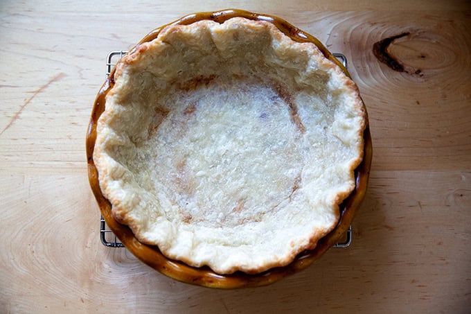 A parbaked pie shell on a cooling rack.