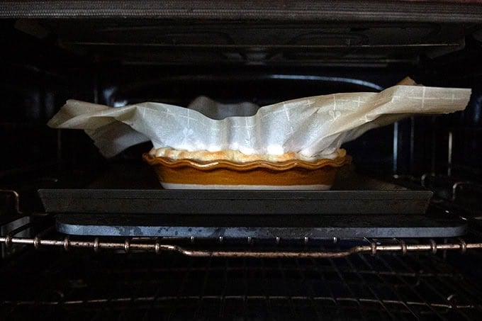 A pie crust parbaking in the oven on a baking steel.