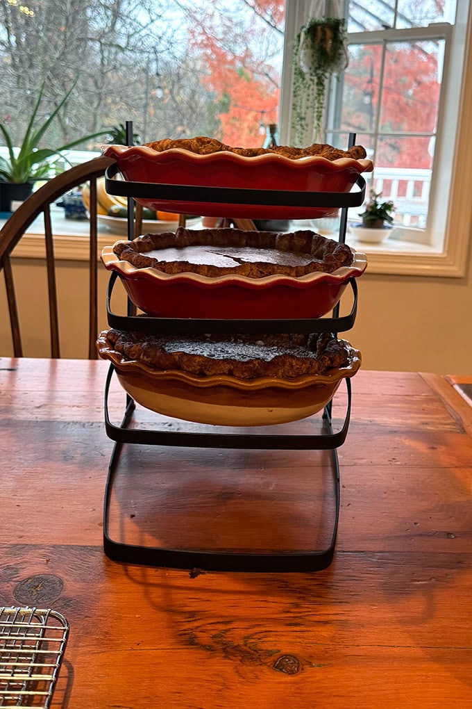 A collapsable cooling rack holding pies.