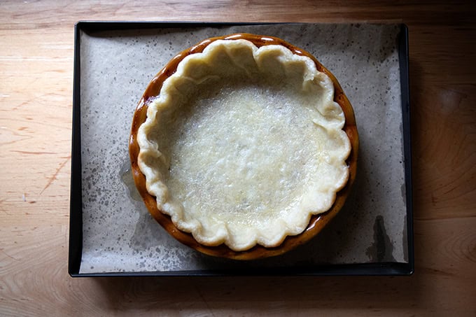 A pie plate lined with a parbaked pie crust.