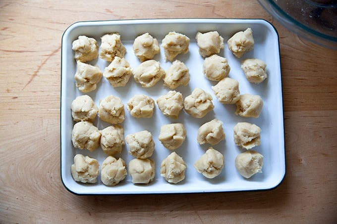 A tray of portioned lemon-almond snowball cookie dough balls.