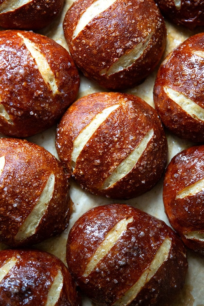 Just-baked pretzel rolls on a sheet pan.
