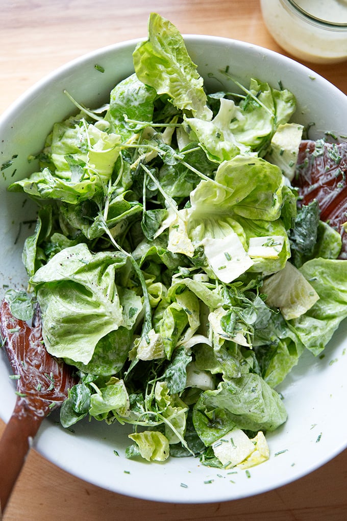 A salad dressed in ranch dressing.