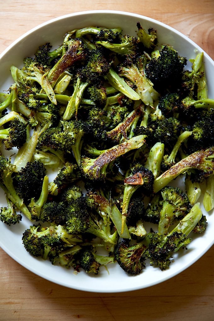 A serving bowl filled with garlic-roasted broccoli with lemon and parmesan.