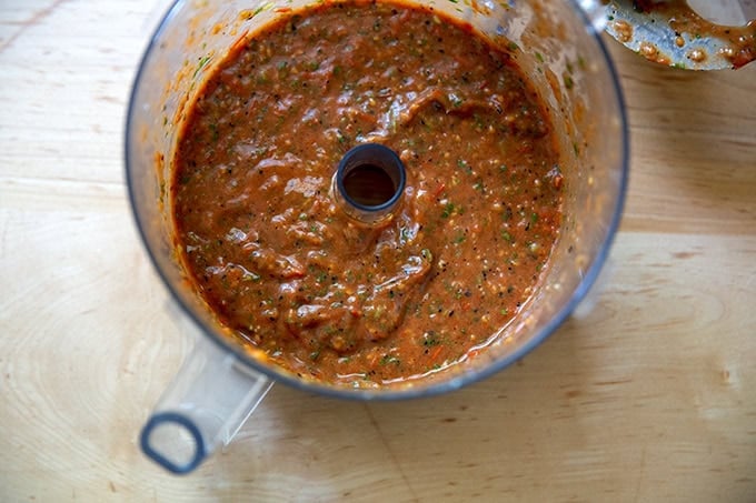 A food processor filled with blistered tomato salsa.
