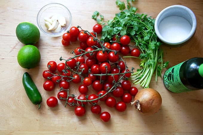 The ingredients to make charred tomato salsa on the countertop.