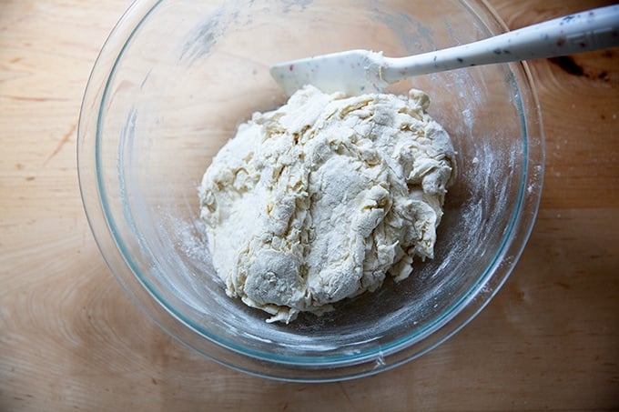 A bowl of shaggy, just-mixed pretzel roll dough.