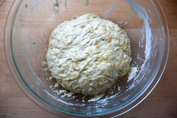 A bowl of oatmeal maple bread dough, deflated after the first rise.