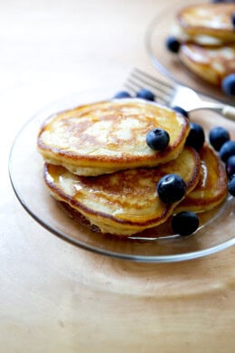 A plate of sourdough discard pancakes topped with syrup and blueberries.