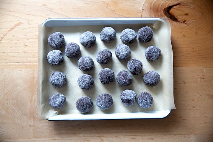 Chocolate crinkle cookie dough balls rolled in sugar on a small tray.