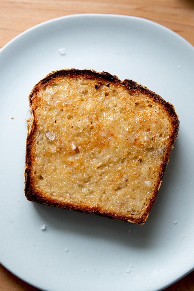 A slice of toasted oatmeal maple bread on a plate.