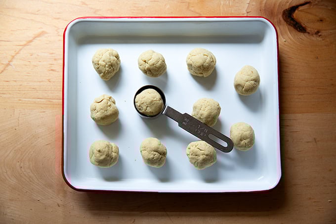 Portioned corn tortilla dough balled up on a tray.