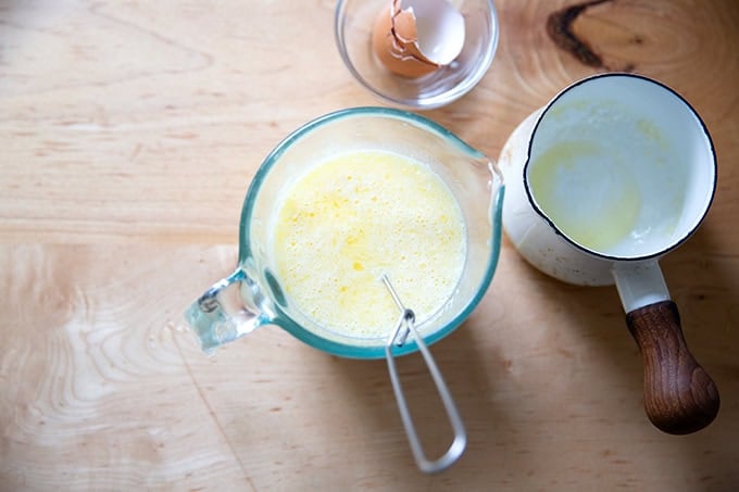 The wet ingredients to make hot cross buns all whisked together in a 2-cup measure.