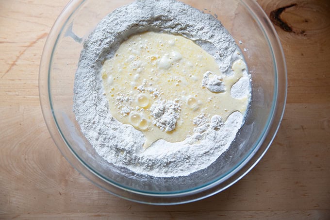 The wet ingredients for hot cross buns added to the dry ingredients for hot cross buns.