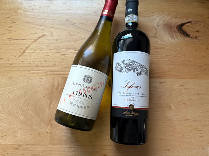 Two bottles of wine on a countertop.