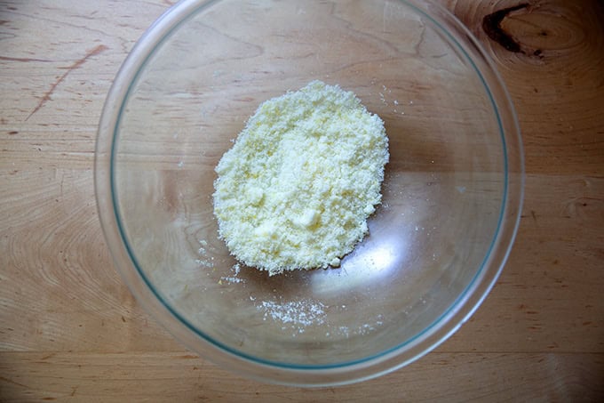 A bowl filled with 1/2 cup of sugar with lemon zest rubbed into it.