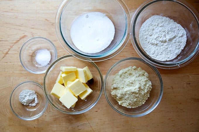 The ingredients to make a crisp topping measured on the countertop: flour, sugar, butter, almond flour, salt, and baking powder.