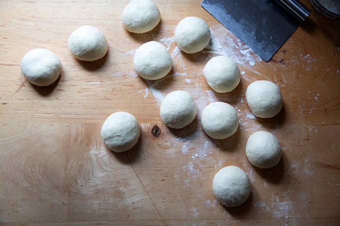 Twelve small dough balls on a countertop.