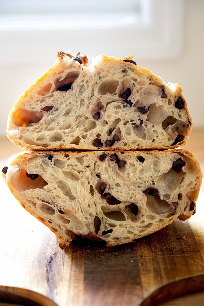 A halved loaf of rosemary-olive sourdough bread.