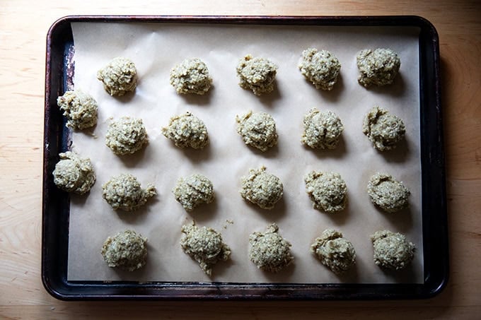 Portioned eggplant meatballs on a sheet pan, unbaked.