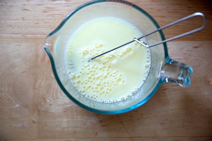 The wet ingredients to make brioche hot dog buns all whisked together.