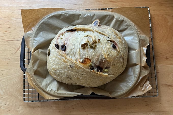 A parbaked loaf of rosemary-olive sourdough bread.
