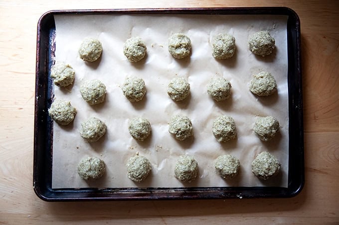 Shaped eggplant meatballs unbaked on a sheet pan.