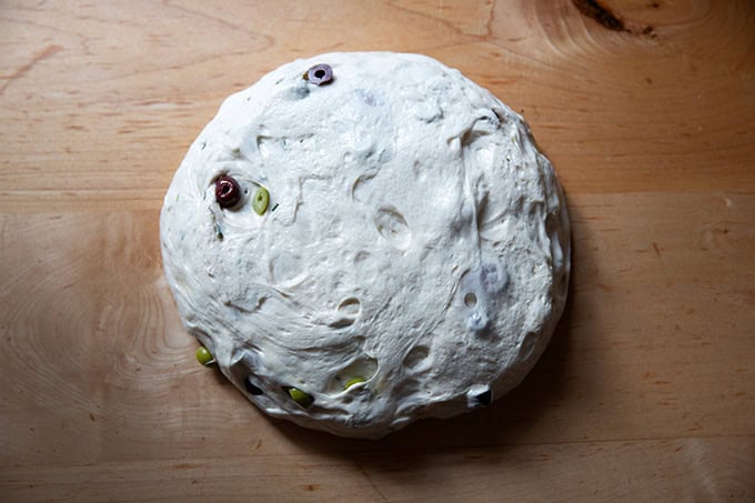Rosemary-olive sourdough dough turned out onto a countertop.