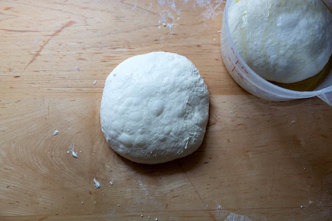 Balled-up grandma-style pizza dough on a counter top.