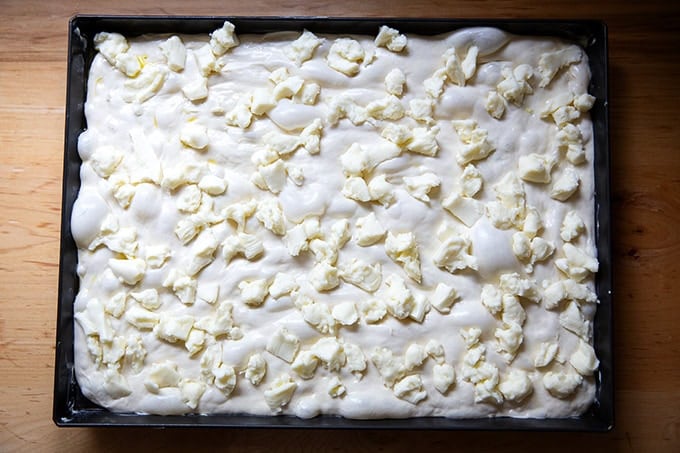 Grandma-style pizza dough topped with cheese.