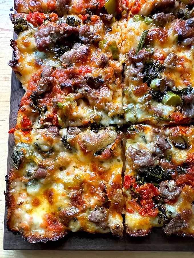 Just-baked grandma-style pizza on a cutting board.