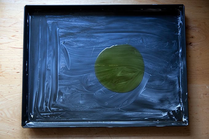 A Lloyd grandma-style pizza pan, buttered and drizzled with 1 tablespoon of olive oil.